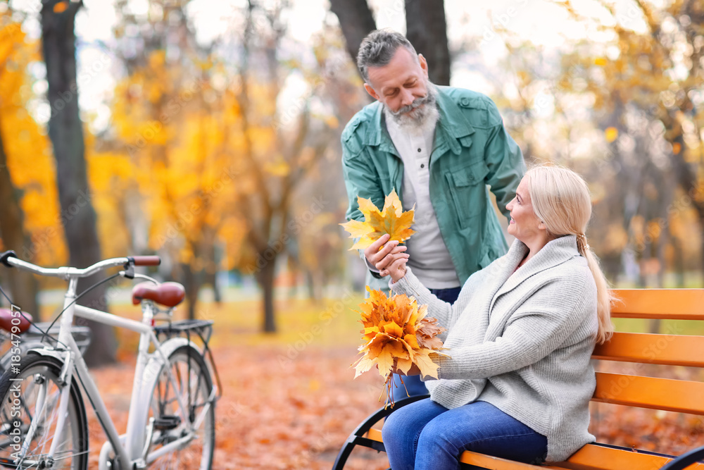 Senior couple resting after bike ride in park Senior couple resting after bike ride in park