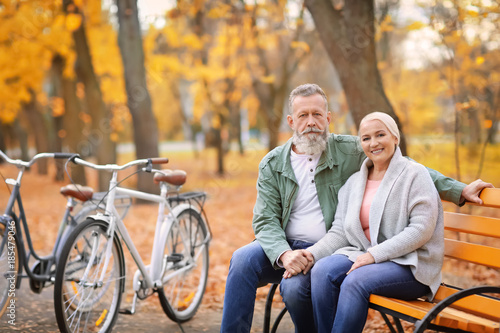 Senior couple resting after bike ride in park