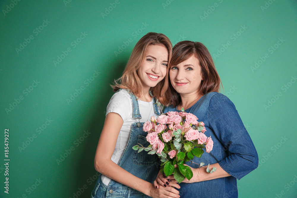 Attractive young woman with her mother on color background Attractive young woman with her mother on color background