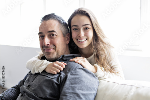 Teenager girl sitting on window with father