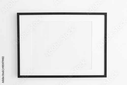 Empty black frame on white wall