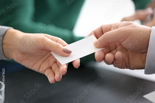 Notary giving business card to client in office