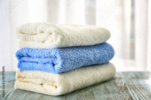 Stack of bath towels on table against light background