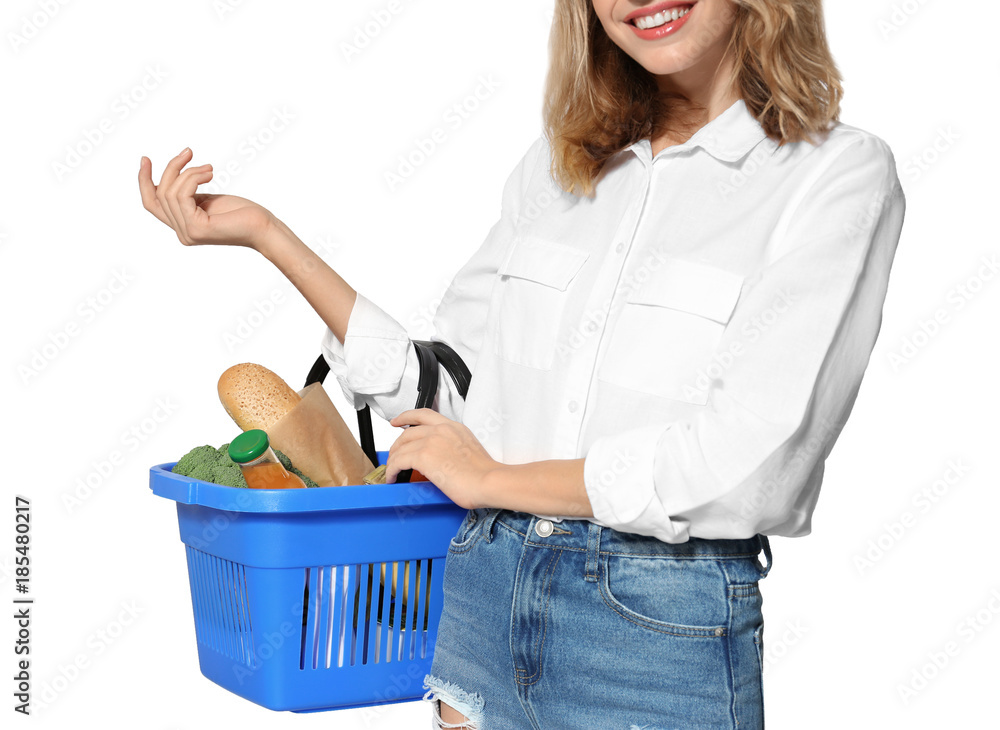 Young woman holding shopping basket with groceries on white background Young woman holding shopping basket with groceries on white background