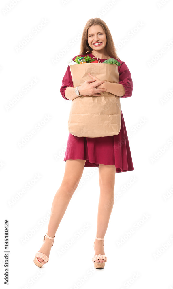 Young woman holding paper bag with groceries on white background Young woman holding paper bag with groceries on white background