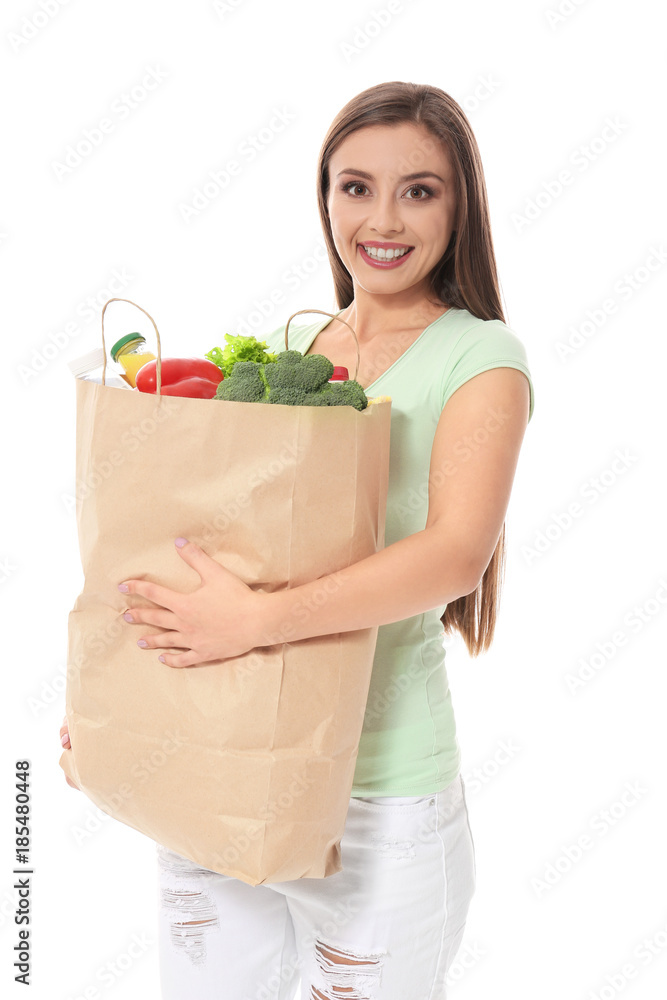 Young woman holding paper bag with groceries on white background Young woman holding paper bag with groceries on white background