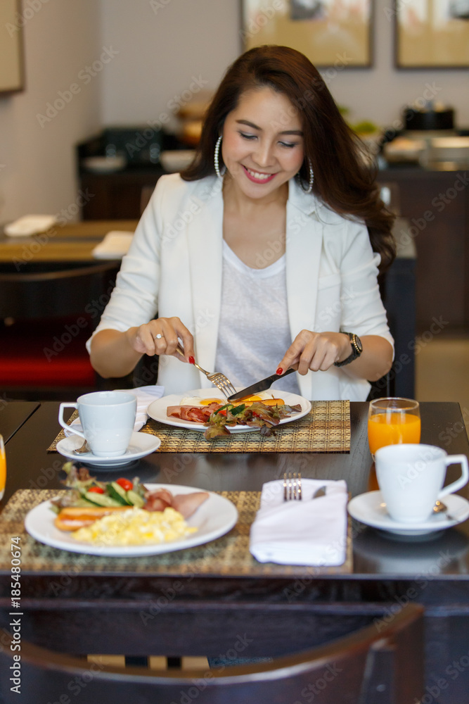 women seating to eat breakfast and drinks, with both orange juice and coffee on the table