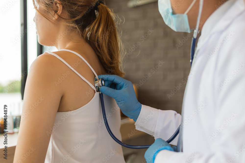 Φωτογραφία The doctor holding a stethoscope and put it on the woman patient's back at the Hospital