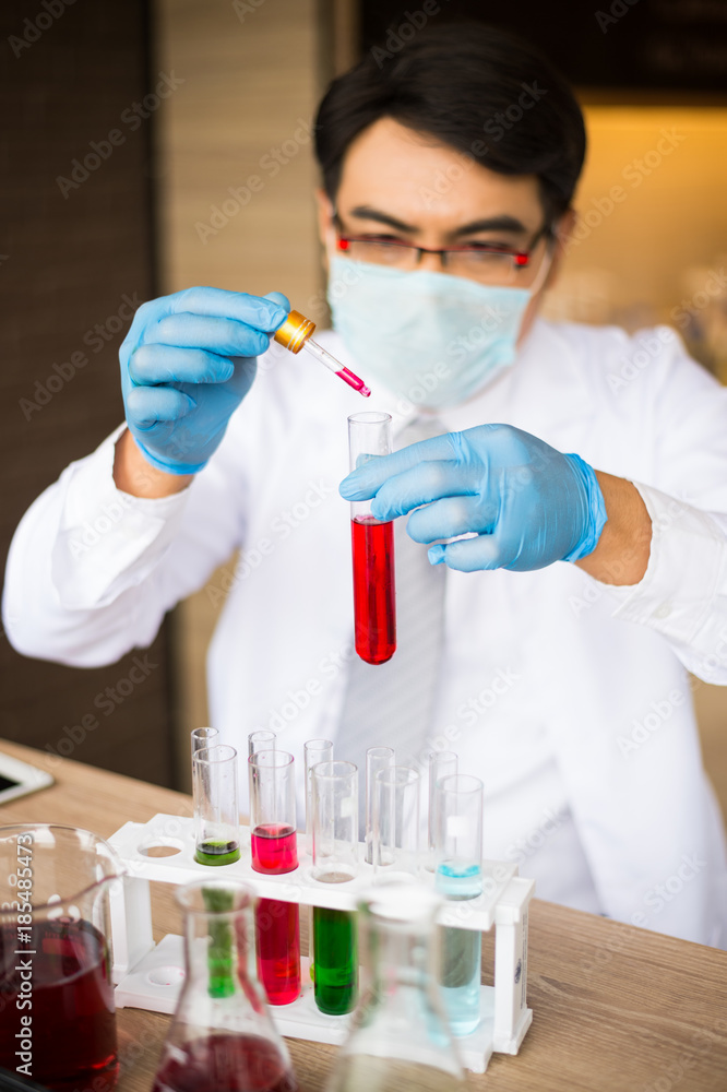 scientist wear white coat and blue gloves holding dropper and drop red water to tube science. Chemist examines chemical test tube, science, doctor scientist wear white coat and blue gloves holding dropper and drop red water to tube science. Chemist examines chemical test tube, science, doctor