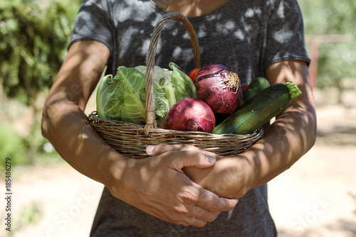 young man with a basket full of vegetables photo