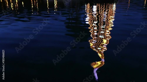 Close-up illuminated decorated New Year tree reflected in the water. Huelin Park, Malaga city, Andalusia, Spain photo