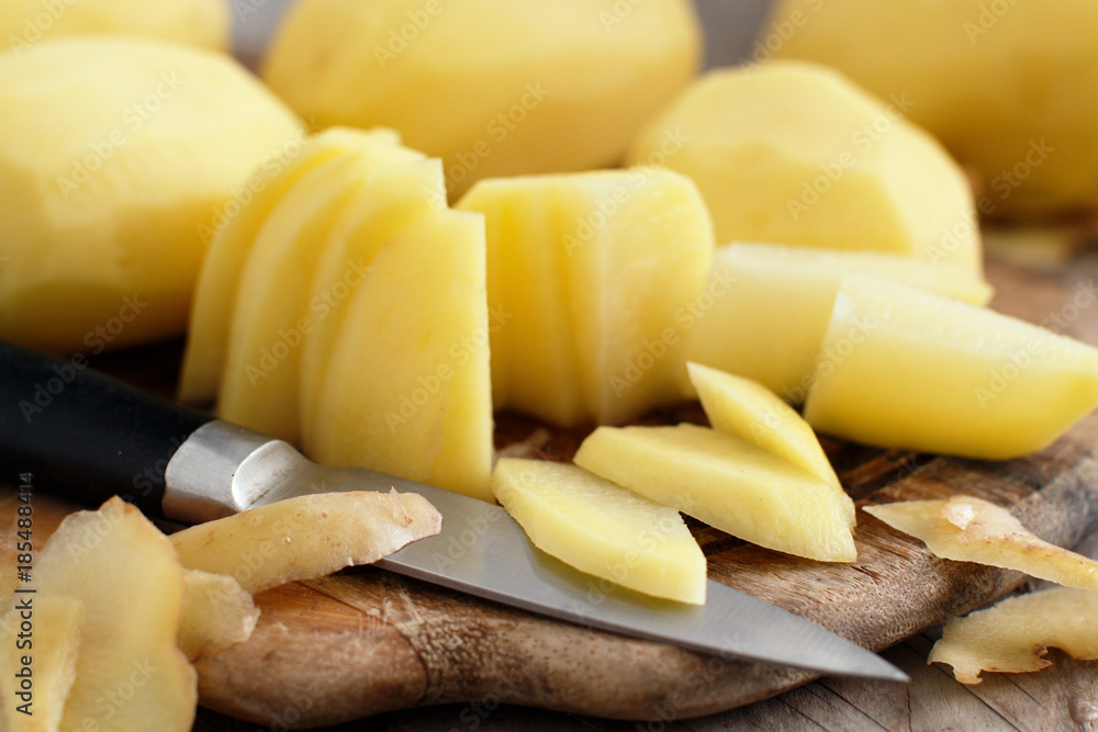 Raw peeled potatoes with a knife Raw peeled potatoes with a knife