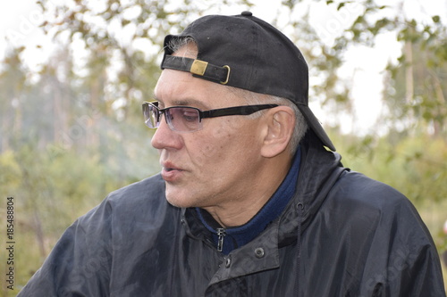 кавказский мужчина выдыхает дым сигаретный 