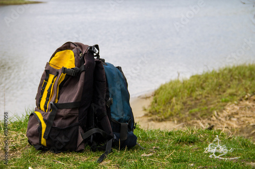 Two touristic backpacks on the riverbank. Hike concept