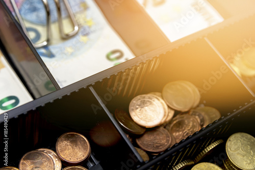 Cash register with coins and paper money