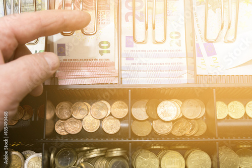 Cash register with coins and paper money