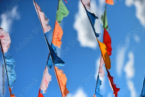 Colorful Prayer flags flying in wind with white clouds and blue sky in Inner Mongolia photo