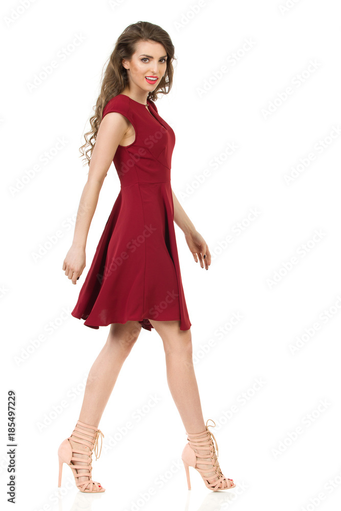 Beautiful Woman In Red Dress And High Heels Is Walking. Side View. Beautiful Woman In Red Dress And High Heels Is Walking. Side View.