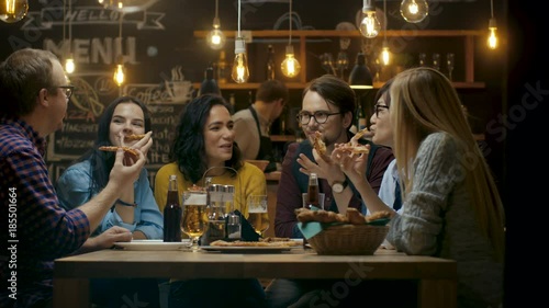 In the Bar/ Restaurant Group of Diverse Young People Eat Slices of Pizza Pie. They Talk, Tell Jokes and Have Fun in This Stylish Establishment. Shot on RED EPIC-W 8K Helium Cinema Camera.