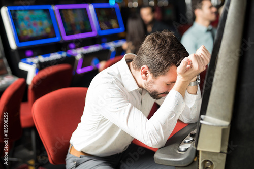 Stressed man losing money in a casino photo