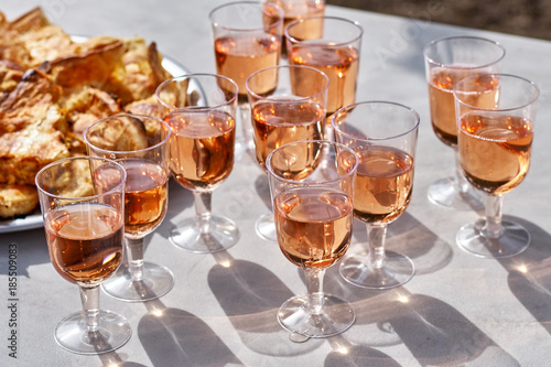 Refreshing pink wine in a glass with cakes on a table, against the background of a vineyard. the concept of winemaking.