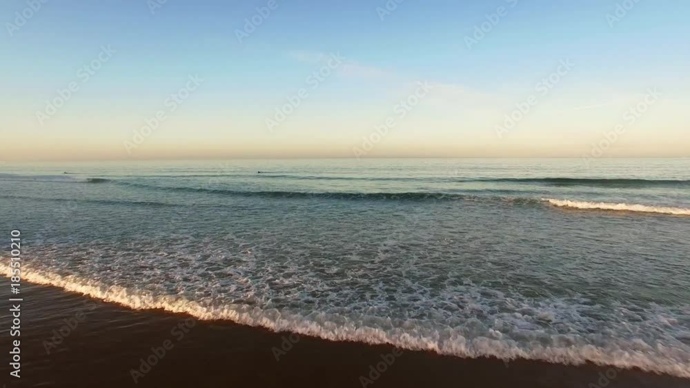 Lonely surfer in ocean at early morning, aerial view Lonely surfer in ocean at early morning, aerial view