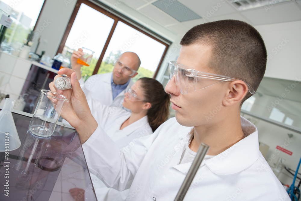 young chemist combining chemical liquid in the lab young chemist combining chemical liquid in the lab