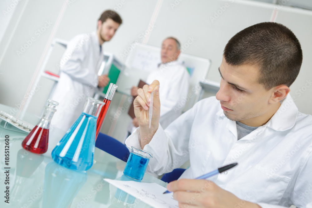 male medical laboratory young researcher performs tests with blue liquid male medical laboratory young researcher performs tests with blue liquid
