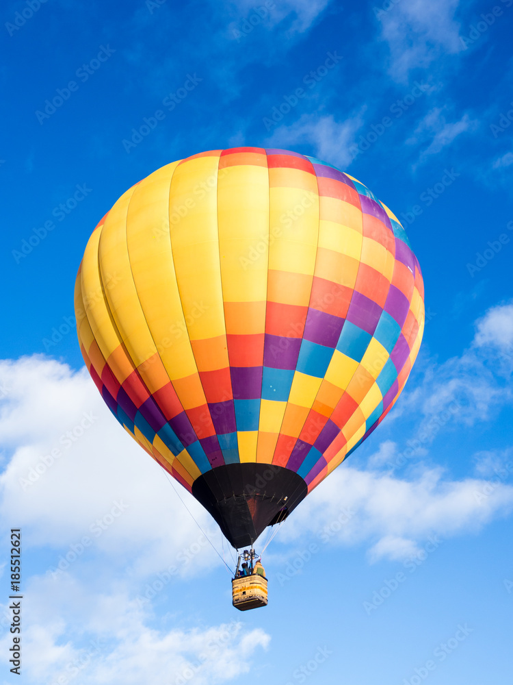 Fototapeta premium Colorful hot air balloon flying in the bright blue sky during Winthrop Balloon Festival in Washington state