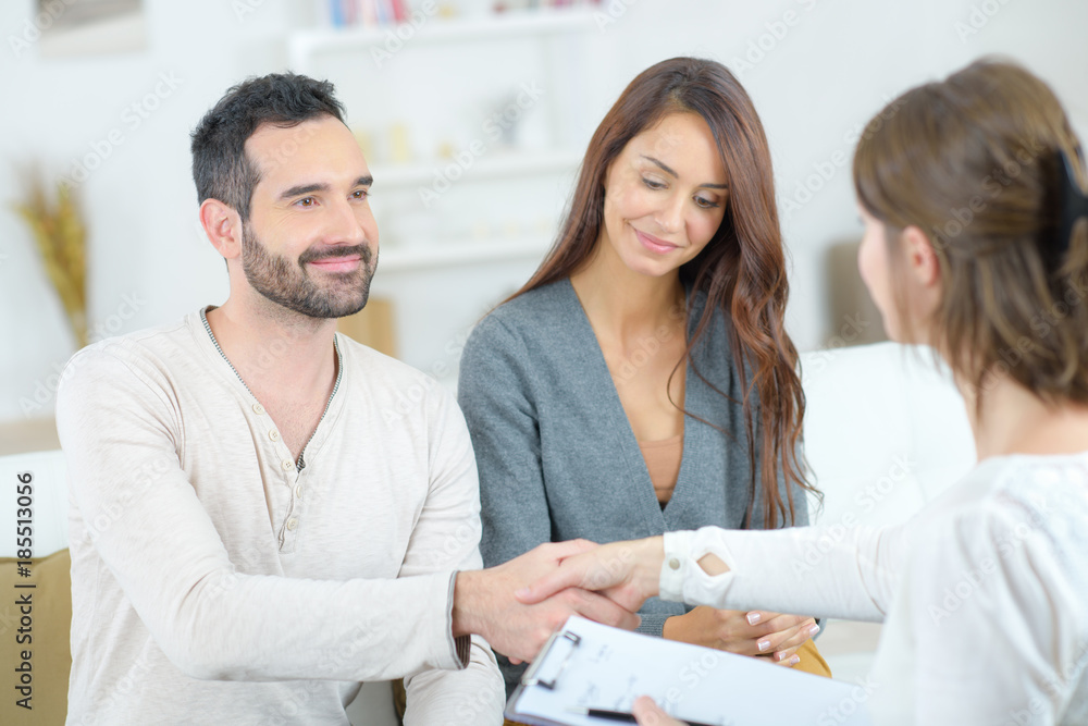 Man shaking hands with lady holding clipboard Man shaking hands with lady holding clipboard