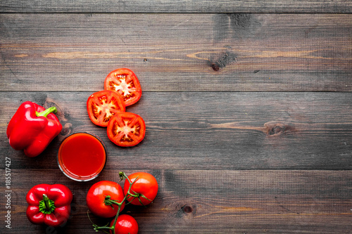 Red detox beverage with paprika and tomatoes on dark wooden background top view copyspace