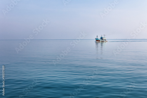 Lonely boat at Andaman blue sea in calm weather, Thailand