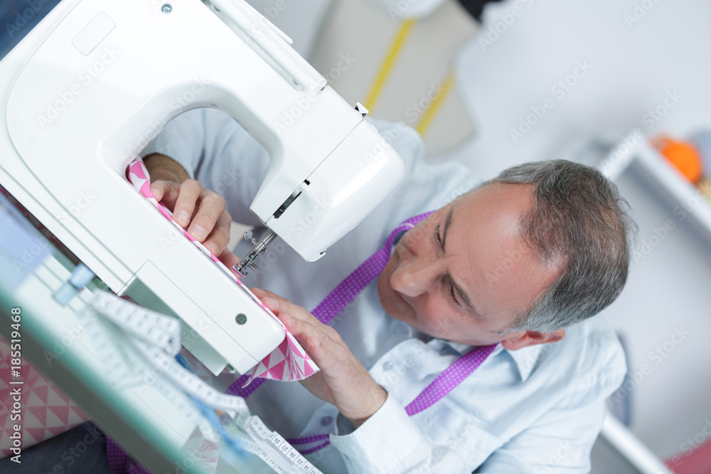 Fototapeta premium mature tailor working at sewing machine