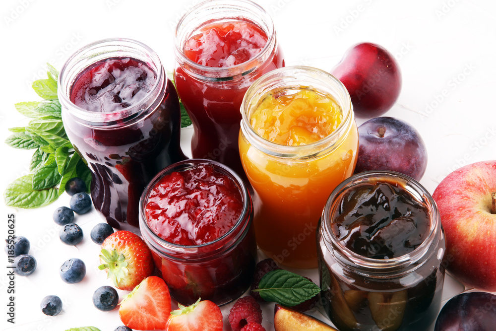 assortment of jams, seasonal berries, plums, mint and fruits.