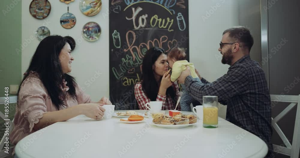 Happy family sitting at the kitchen table taking vrea and playing with the baby child. 4k. red epic Happy family sitting at the kitchen table taking vrea and playing with the baby child. 4k. red epic