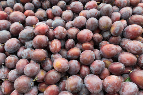 Fresh Red Plum Stack on Market Stall For Sale