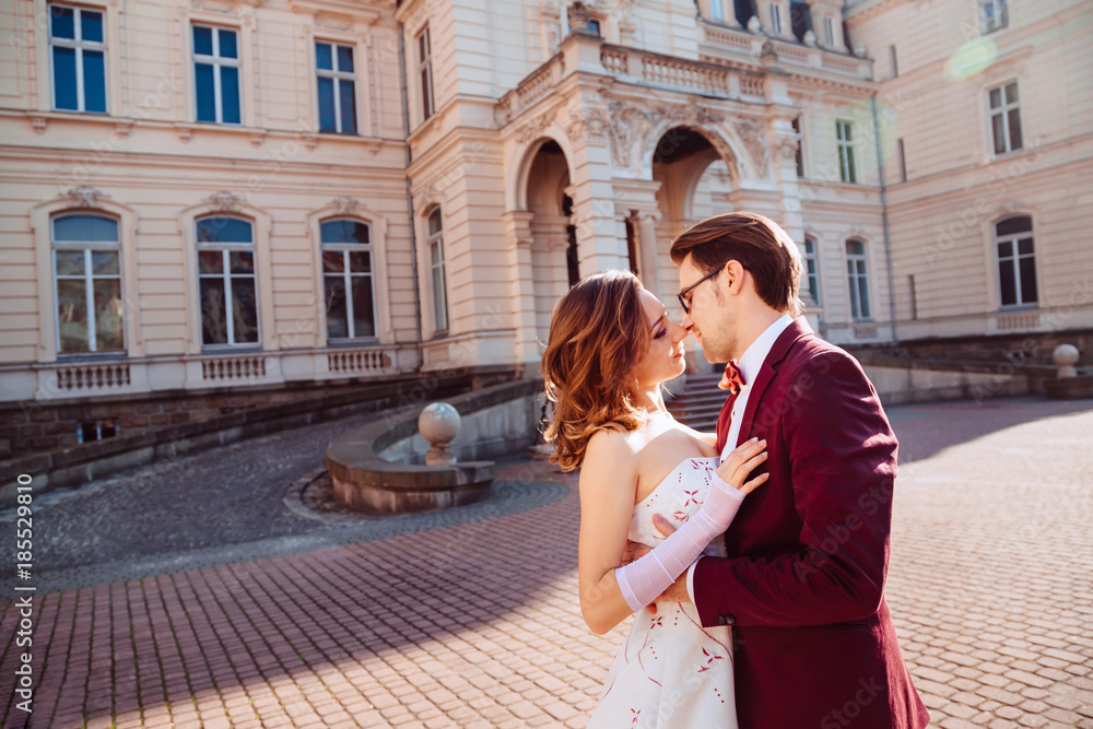 Fototapeta premium gentle embrace of the bride and groom in a sunny day near the pa