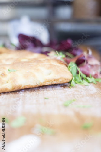 Preparing focaccia pizza with arugula, ham, cheese and radicchio photo