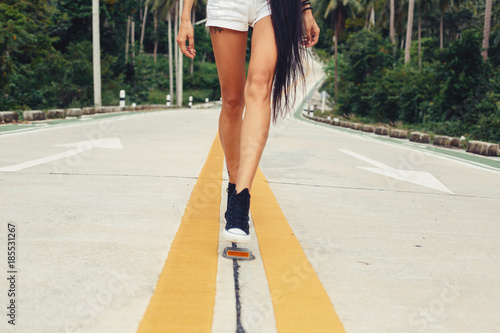 Female Legs wearing sneakers on the road. Travel concept