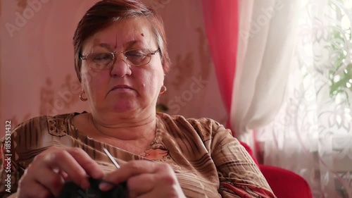 Wallpaper Mural Senior woman knitting a scarf from natural goat hair with needles at home. Torontodigital.ca