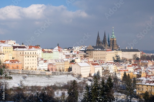 Prague castle and snowy roofs of Mala Strana from Seminarska Garden in Prague, Czech republic