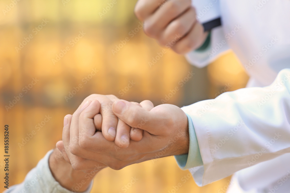 Young caregiver holding hands with senior man, closeup Young caregiver holding hands with senior man, closeup