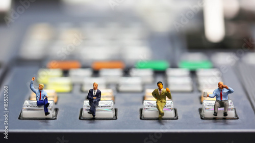 Miniature people : businessman sitting on switcher control of Television Broadcast,color buttons photo