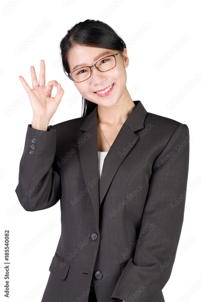 Young smiling businesswoman showing okay hand gesture, on white background. Asian model in business success concept. Young smiling businesswoman showing okay hand gesture, on white background. Asian model in business success concept.