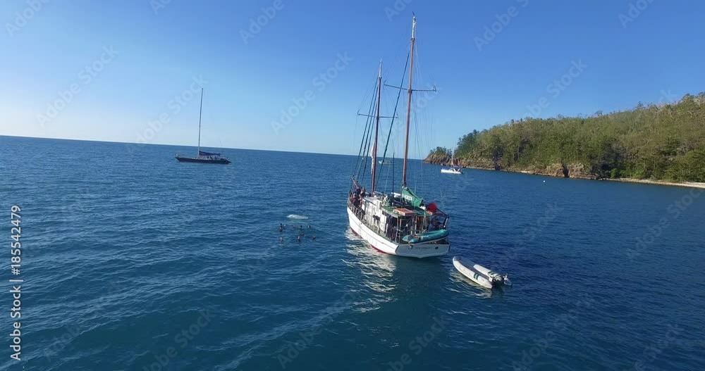 WHITSUNDAY ISLANDS – FEBRUARY 2016 : Aerial shot of sailboat on a beautiful day with divers and motorboats in view WHITSUNDAY ISLANDS – FEBRUARY 2016 : Aerial shot of sailboat on a beautiful day with divers and motorboats in view