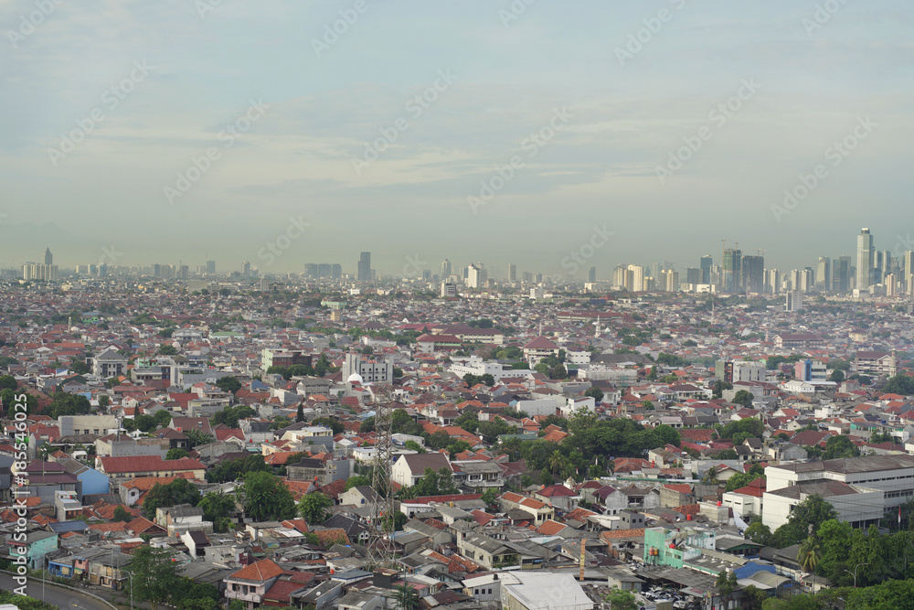 Cityscape of Jakarta city with buildings, houses, and busy road.