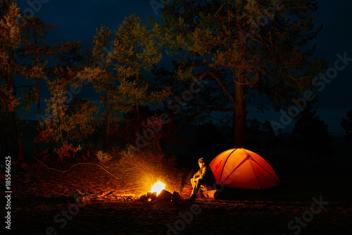 A man sits by the fire near a tent on the shore of Lake Baikal photo
