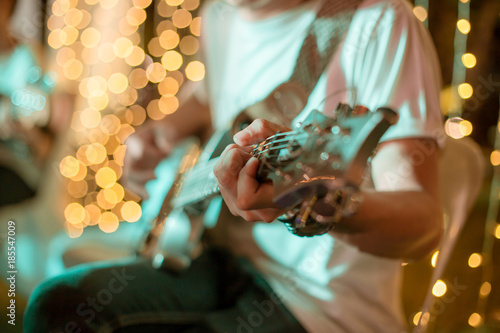 Hand of Musician with guitar on night time. photo