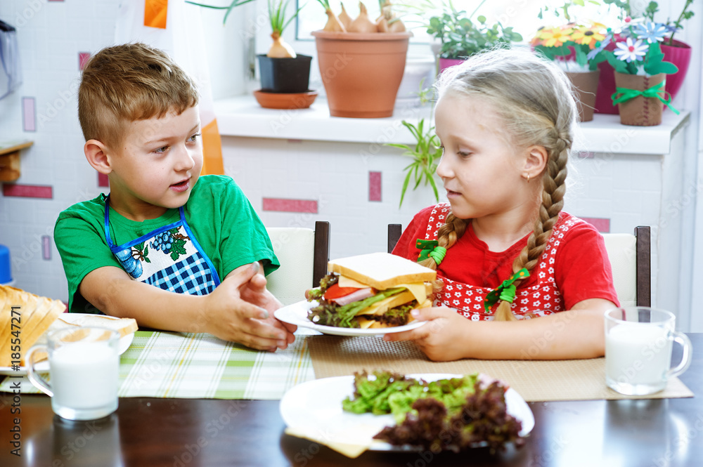 Children make sandwiches in the kitchen . Funny kids make sandwiches Children make sandwiches in the kitchen . Funny kids make sandwiches