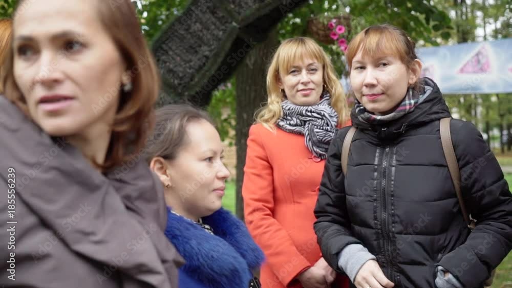 A small crowd of women gathered in the park. A small crowd of women gathered in the park.